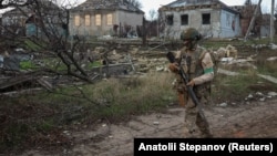 Український військовий на тлі приватних будинків, пошкоджених внаслідок російського удару по Костянтинівці, 7 грудня 2025 року