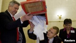 Members of a local election committee emptied a ballot box after polls closed in Minsk in the country's last election, the December 19 presidential vote that sparked protests and a brutal crackdown.