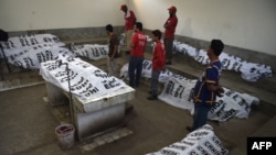 Pakistani volunteers gather around the bodies of fire victims at a hospital following a fire at Regent Plaza Hotel in Karachi on December 5.