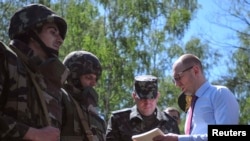 Prime Minister Arseniy Yatsenyuk (right) meets with military personnel during a visit to a national-guard training camp near Kyiv on May 22.