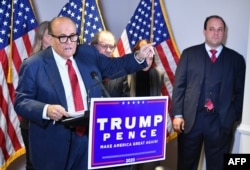 Бывший адвокат Трампа Рудольф Джулиани выступает на пресс-конференции с утверждениями о подтасовке результатов президентских выборов 2020 года. 19 ноября 2020 года