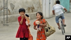 Ethnic Uzbek girls walk along a street just outside the southern city of Osh in June.