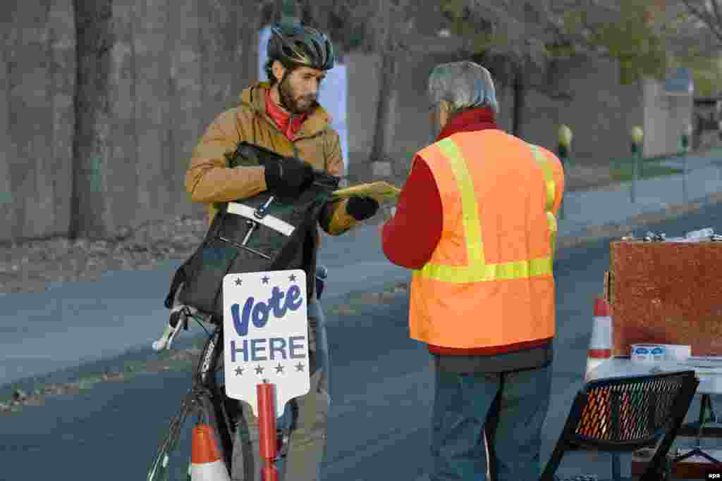A cyclist drops off his ballot at polling location in Denver, Colorado.