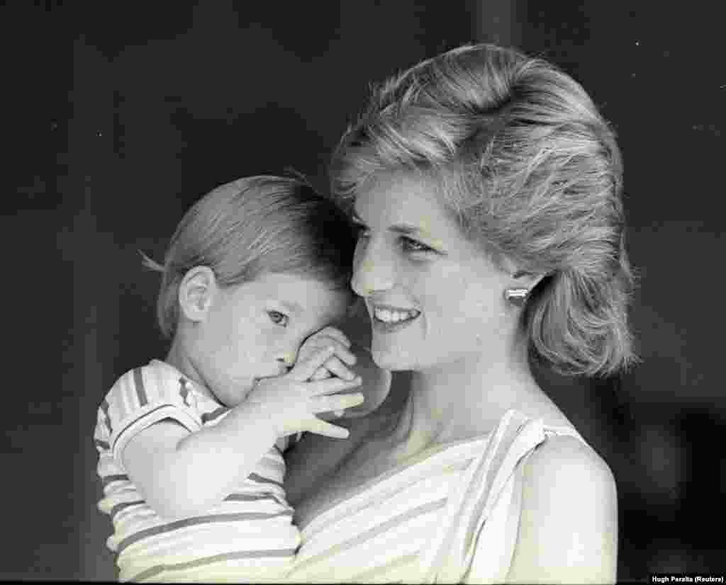 Маленький принц Гарі намагається сховатися за свою маму, принцесу Діану, під час ранкової фотосесії у палаці Марівент (Пальма-де-Майорка, Іспанія) 9 серпня 1988 року, де принц та принцеса Уельські гостювали в іспанських короля Хуана Карлоса та королеви Софії.&nbsp;