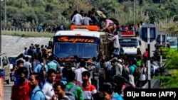 Assam ştatında insanlar evlərinə getmək üçün ağzınacan dolu avtobusun damına çıxırlar