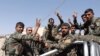 Fighters of the Syrian Democratic Forces gesture a "V" sign to the media as they ride a truck on the way to the frontline in Raqqa, October 8, 2017