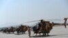An Afghan pilot stands next to a line of U.S.-made MD-530 helicopters in Kabul.
