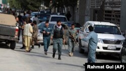 Afghan security personnel arrive at the site where the director of Afghanistan's government's Information and Media Center, Dawa Khan Menapal, was assassinated in Kabul on August 6.