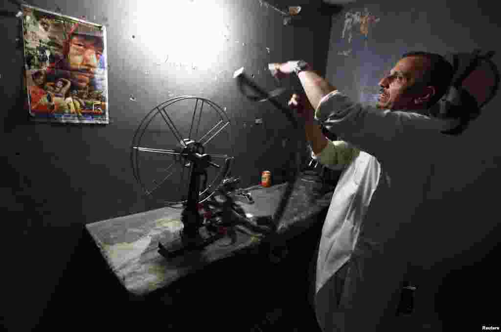A worker checks a negative of an old Pashto movie at the Arshad cinema in Peshawar. Pashto cinema, or Pollywood, which once made its home in Peshawar, is now confined to a handful of theaters that haven&#39;t been attacked by Islamists. (Reuters/Zohra Bensemra)