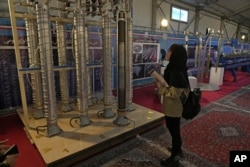 În imagine, un student privește utilaje de centrifugare construite în Iran, la Teheran, în 2023.