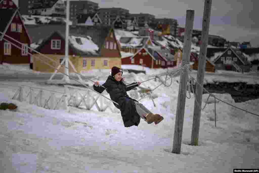 Hans, 9 vjeç, duke u luhatur në litarë të përdorur si mbajtës për barkat në Nuk, Grenlandë, të dielën, 16 shkurt 2025.