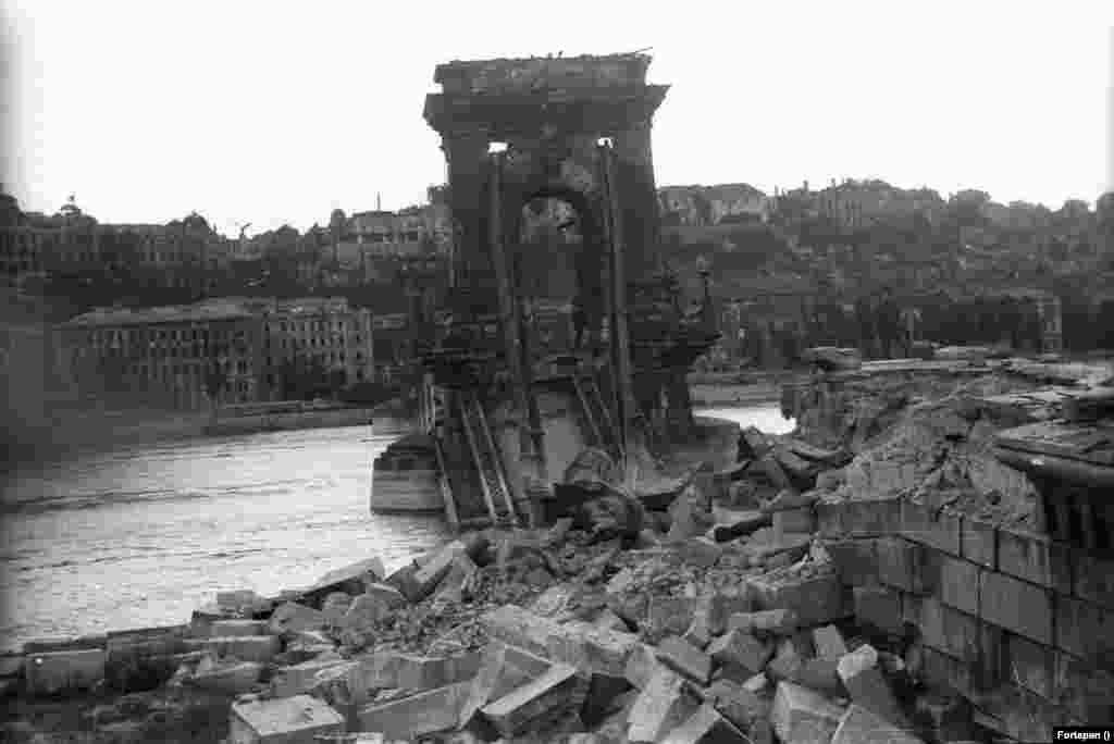 A lerombolt Széchenyi Lánchíd pesti hídfője, háttérben a romos királyi palota (ma Budavári Palota). A hidat 1945. január 18-án robbantotta fel a visszavonuló német hadsereg.