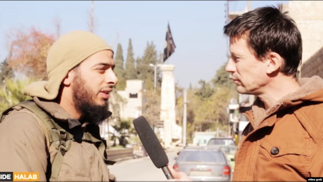 A screen shot from a video showing a French Islamic State militant (left) talking to British hostage John Candlie