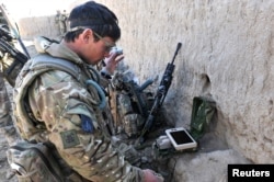 Egy brit katona a Black Hornet egy korai változatának indítására készül egy afganisztáni harci művelet során 2013-ban