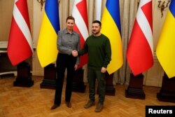 Премьер-министр Дании Мэтте Фредериксен и президент Украины Владимир Зеленский пожимают руки во время встречи во Дворце Потоцких во Львове, 23 февраля 2024 года