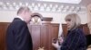 Ella Pamfilova, the chairwoman of the Central Election Commission, hands Russian President Vladimir Putin his identity card after his election victory, during their meeting at the Kremlin in Moscow, April 3, 2018