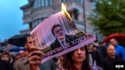 A protestor burns a picture of Macedonia's former Prime Minister Nikola Gruevski. The Balkan country has been in political turmoil since February 2015 over a wiretapping scandal.