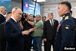 Путін говорить з героєм РосіДашибалом Мункожаргаловим під час візиту до Бурятського державного університету в Улан-Уде, Росія, 10 серпня 2026 року