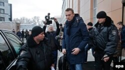 Судебные приставы сопровождают Навального на выходе из его московского офиса. 31 января 2017 года.
