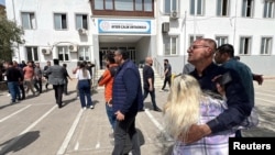 Njerëz presin para ndërtesës së shkollës pas sulmit vdekjeprurës, në provincën juglindore të Kahramanmarasit, Turqi, 15 prill 2026.