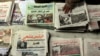 An Egyptian newspapers vender guards his papers fronted by pictures of the current situation in Egypt, Saturday, Feb. 5, 2011. President Barack Obama said Egypt's Hosni Mubarak should do the statesmanlike thing and make a quick handoff to a more represent