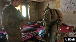 U.S. soldiers search through a weapons and ammunition cache found at a hotel in eastern Afghanistan in July.