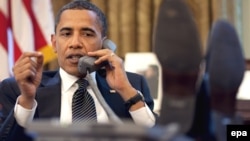 АҚШ президенті Барак Обама стол үстіне аяқтарын қойып, телефонмен сөйлесіп отыр. Вашингтон, 8 маусым 2009 жыл.