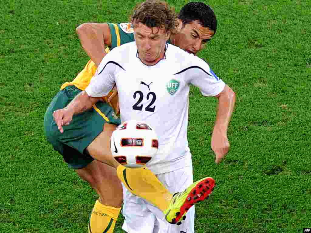 Qatar -- Australia vs Uzbekistan at the 2011 Asian Cup semi-final football match in Doha, 25Jan2011 - QATAR, Doha : Australia's striker Tim Cahill (back) challenges Uzbekistan's midfielder Victor Karpenko during their 2011 Asian Cup semi-final football match at Khalifa Stadium in the Qatari capital Doha on January 25, 2011. AFP PHOTO / PORNCHAI KITTIWONGSAKUL 