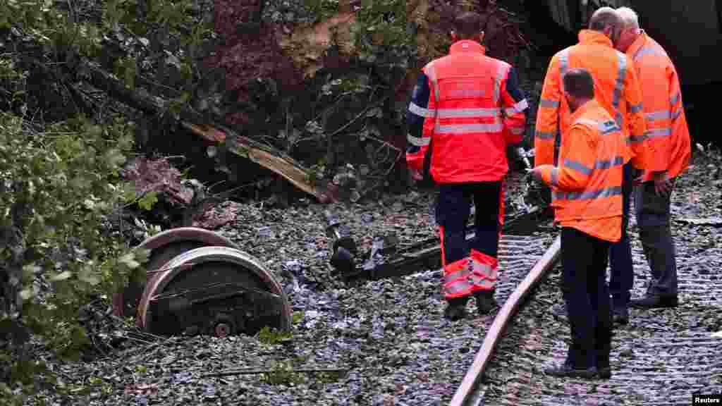 A német vasúttársaság, a Deutsche Bahn munkatársai vizsgálják a vonatbaleset helyszínét július 28-án reggel