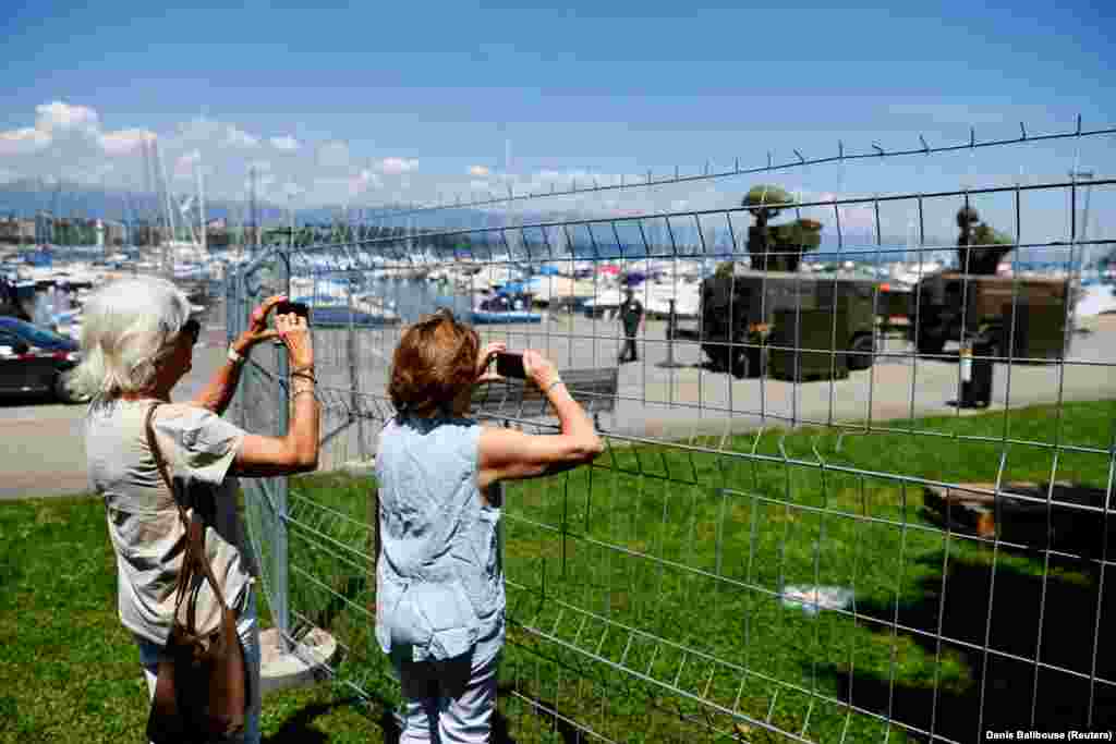 People take photos of a Swiss military radar system set up on the shore of Lake Geneva on June 11.&nbsp;