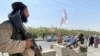 Taliban fighters stand guard at an entrance gate outside the Interior Ministry in Kabul on August 17. 