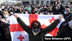 A Georgian opposition supporter holds a national flag during a rally following the arrest of the leader of the opposition ENM party in Tbilisi on February 23. 