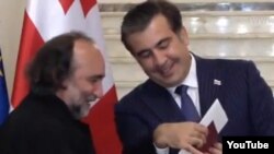 President Mikhail Saakashvili (right) presents Russian conductor Mikhail Arkadyev with a Georgian passport