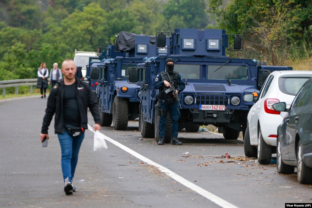An ethnic Serb walks past Kosovar police securing the area near Jarinje on September 28. The EU, NATO, and the United States have all urged Kosovo and Serbia to immediately exercise restraint and refrain from unilateral actions.