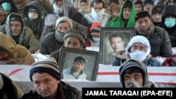 Members of Pakistan's Shi'ite Hazara community gather around the coffins of victims on January 8 to mark the fifth day of protest in the outskirts of Quetta.