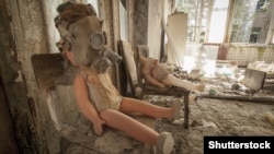 A doll with a gas mask sitting on a chair in an abandoned kindergarten in Pripyat.