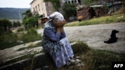 Жительница грузинского города Гори плачет около руин своего дома, разрушенного российскими бомбардировками. 23 августа 2008 года