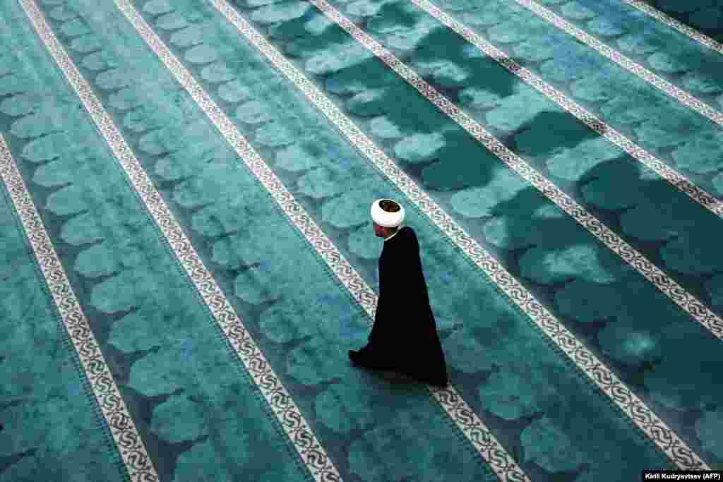 An iman walks across the hall in the Sobornaya Mosque, Moscow&#39;s cathedral mosque, in Moscow on May 23.&nbsp;(AFP/Kirill Kudryavtsev)