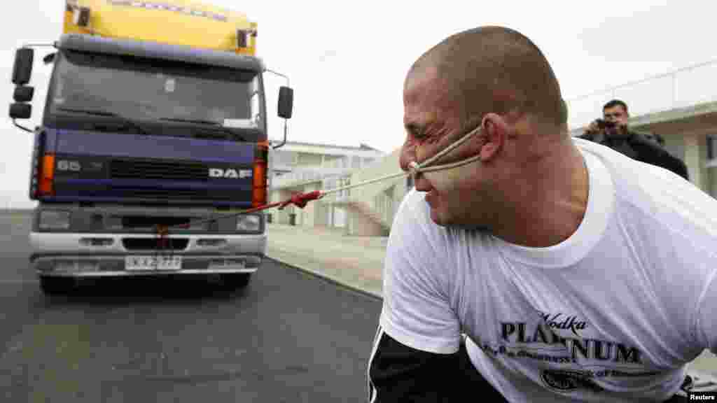 Lasha Pataraya pulls an eight-ton truck with his ear in Rustavi, outside Tbilisi, Georgia. The 32-year-old sportsman will attempt to break a record registered by the Guinness Book of World Records by the end of the month, according to organizers. (Reuters/David Mdzinarishvili)