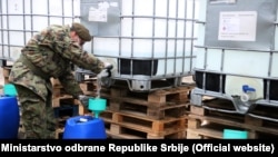 Pripadnik Vojske Srbije toči medicinski alkohol