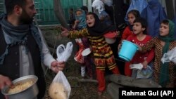 شماری از اطفال افغان در تلاش دریافت غذا. May 12, 2019