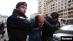 Interior Ministry officers detain a man during a protest against the razing of the Soviet-era apartment blocks outside the State Duma in Moscow on June 14.