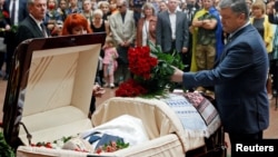 Ukrainian President Petro Poroshenko lays flowers on the coffin containing the body of journalist Pavel Sheremet, who was killed by a car bomb, during a memorial service in Kyiv on July 22.