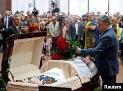 Ukrainian President Petro Poroshenko lays flowers on the coffin containing the body of journalist Pavel Sheremet, who was killed by a car bomb, during a memorial service in Kyiv on July 22.