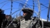 Kosovo -- A US soldier, part of a NATO peace force, places barbed wire on his Humvee during a protest in the ethnically divided town of Mitrovica, June 22, 2014