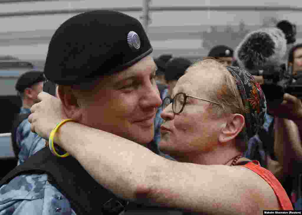 A woman kisses a law enforcement officer during a rally in support of Russian investigative journalist Ivan Golunov, who was detained by police after being accused of drug offenses and then later freed from house arrest, in Moscow on June 12. (Reuters/Maxim Shemetov)