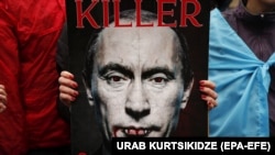 Плакат с изображением президента России Владимира Путина и надписью «Убийца» на акции против российского вторжения в Украину. Тбилиси, 26 ноября 2022 года