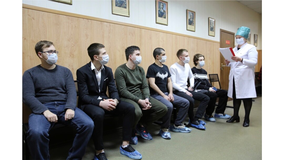A group of Russian conscripts, wearing face masks for protection against the coronavirus, wait for a medical checkup at a military conscription office in Moscow.