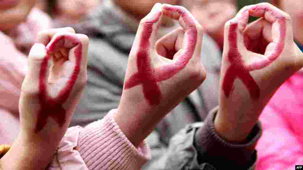 Chinese students show their hands painted to look like red ribbons during a World AIDS Day event at a school in Hanshan, central Anhui Province. (AFP)