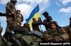 Украинские военные на дороге возле города Лимана, освобожденного ранее ВСУ от российской армии. Донецкая область, 4 октября 2022 года